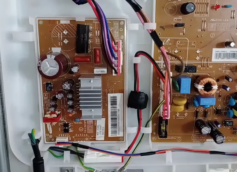 Electronic control boards inside a household appliance during repair and troubleshooting.